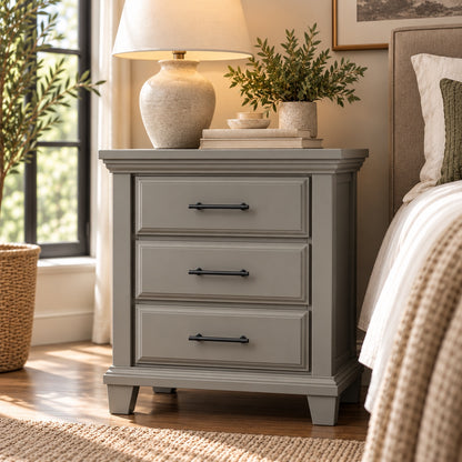 Slate gray Bella three-drawer nightstand with black pulls, in a styled bedroom beside upholstered bed
