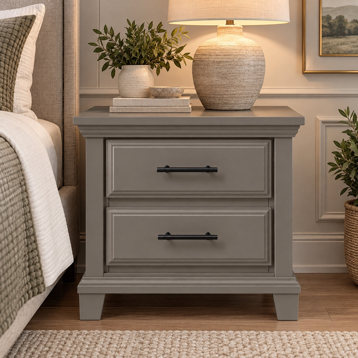 Slate gray Bella classic two-drawer nightstand styled with lamp and plants beside a bed